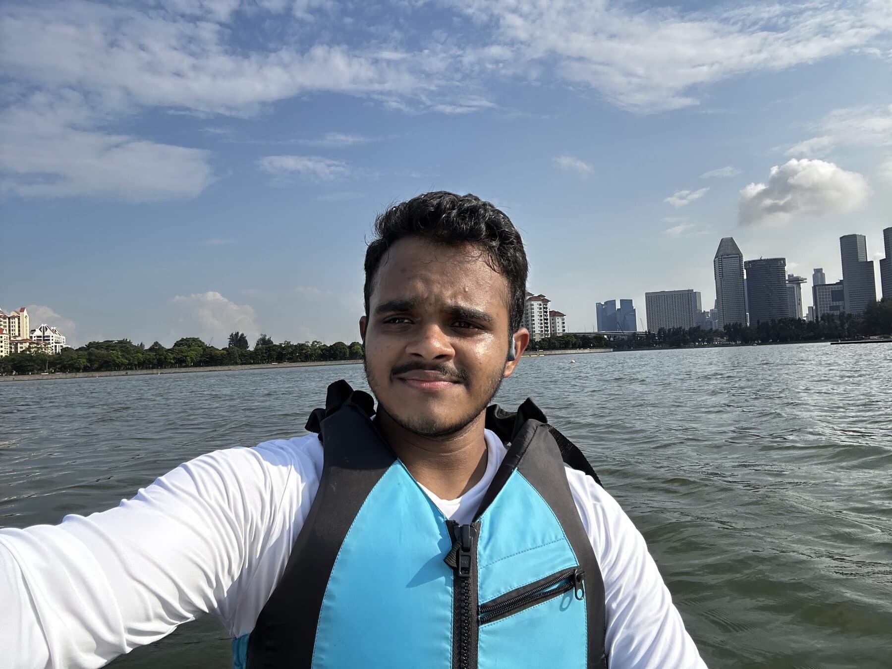Guru Prasath kayaking on a Singapore waterway with the city behind him.